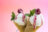 Two waffle cones filled with vanilla ice cream, drizzled with raspberry sauce and garnished with raspberries and mint leaves.
